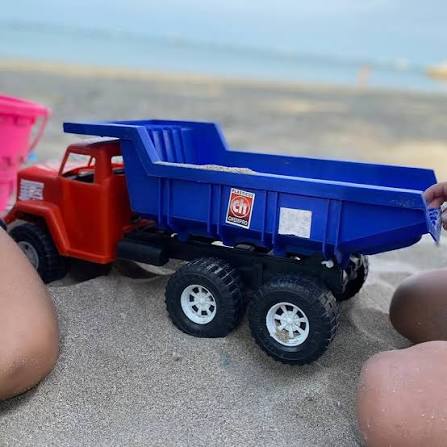 Camión de juguete azul en la playa